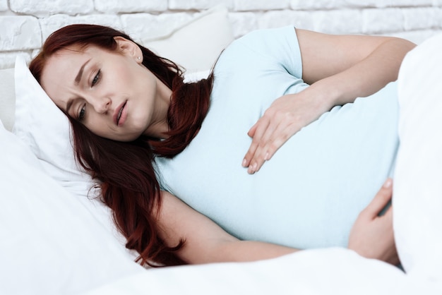 Kobieta w ciąży ma ból brzucha.