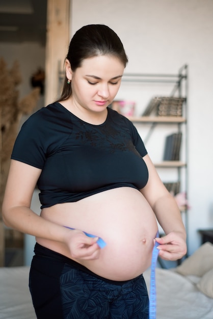 Kobieta w ciąży mierzy jej brzuch