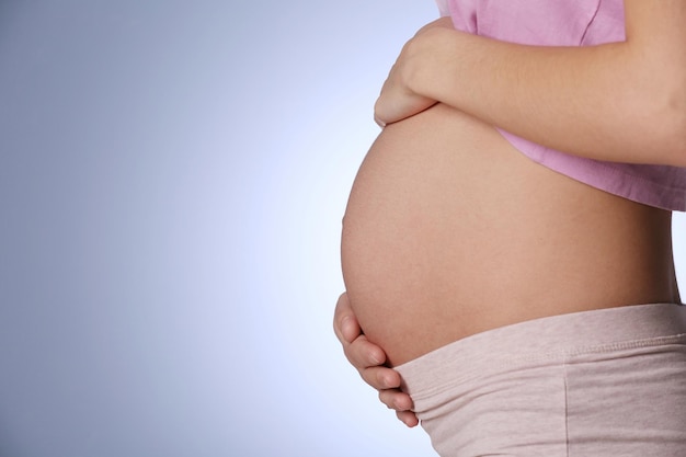 Kobieta w ciąży na niebieskim tle