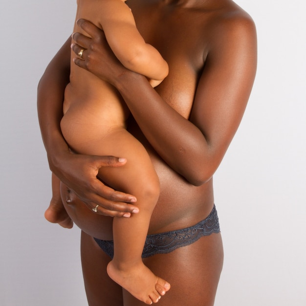 Kobieta w ciąży niosąca dziecko w ramionach