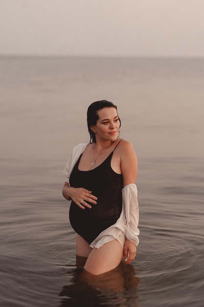 Kobieta W Ciąży O Zachodzie Słońca Na Plaży Nad Morzem