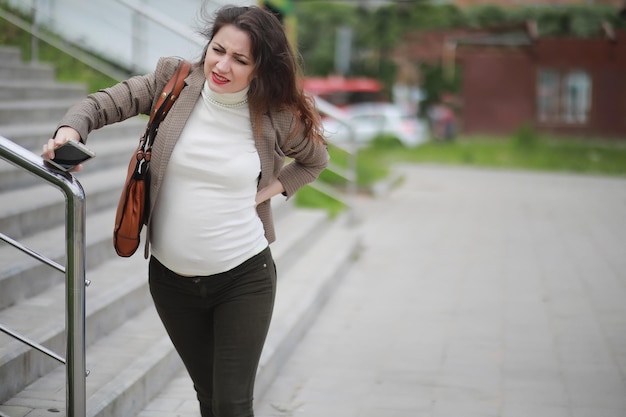 Kobieta w ciąży odczuwa ból na ulicy