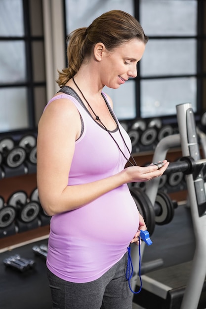 Kobieta w ciąży patrzeje stopwatch w gym