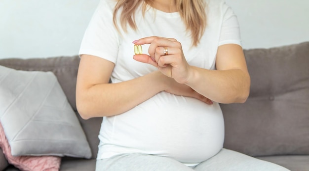 Kobieta w ciąży pije omega trzy Selekcyjna ostrość