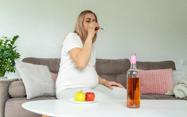 Kobieta w ciąży pije wino w szklance Selektywna ostrość