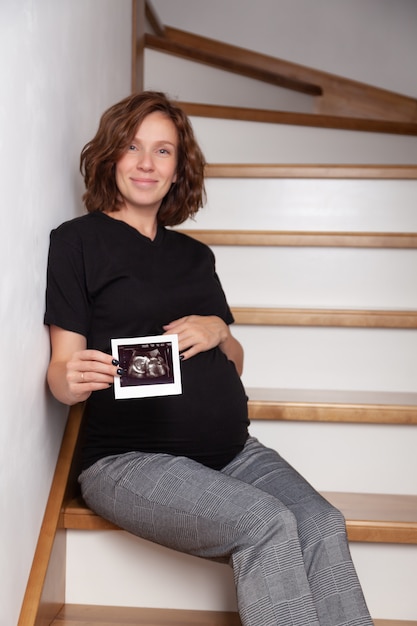 Kobieta w ciąży pokazuje obraz USG
