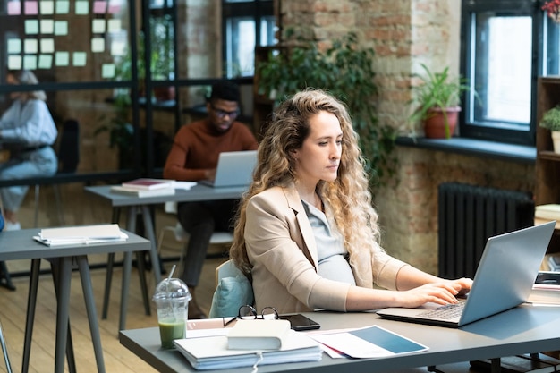 Kobieta W Ciąży Pracuje Na Laptopie W Biurze