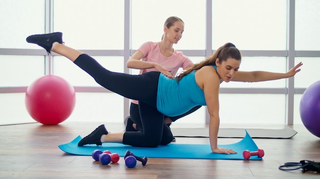 Kobieta W Ciąży Robi ćwiczenia Dla Kobiet W Ciąży Z Osobistym Trenerem Na Zajęciach Fitness. Macierzyństwo I Sport, Dbanie O Swoje Ciało I Zdrowie.