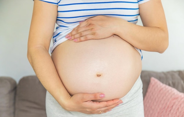 Kobieta w ciąży ściska jej brzuch Selekcyjna ostrość