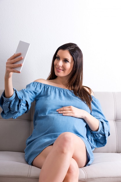 Kobieta W Ciąży Siedzi Na Kanapie I Robi Selfie