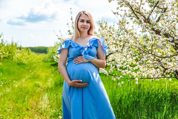 Zdjęcie kobieta w ciąży w ogrodzie kwitnących jabłoni selektywne fokus