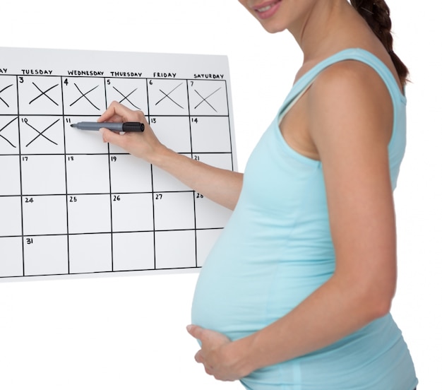 Kobieta w ciąży znakowania daty w kalendarzu