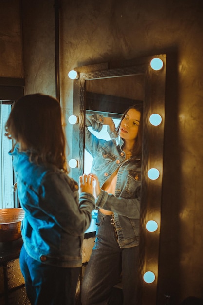 Zdjęcie kobieta w dżinsie patrząca na zdjęcie w lustrze