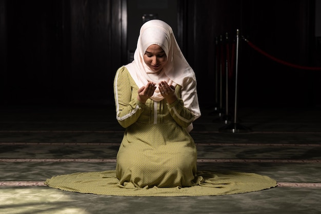 Kobieta w hidżabie siedząca w meczecie i modląca się