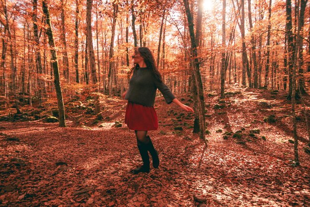 Kobieta w jesiennym krajobrazie bukowego lasu