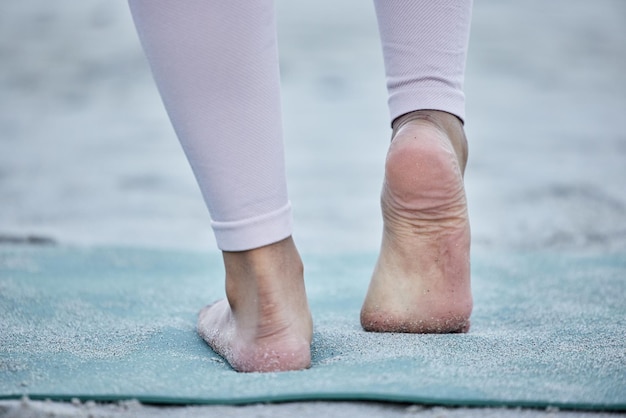 Kobieta w jodze rozciągająca stopy na plaży trenująca nogi w holistycznym ćwiczeniu stóp lub treningu w przyrodzie Fitness wellness lub duchowa dziewczyna zen ćwicząca dla równowagi lub zdrowego, silnego ciała