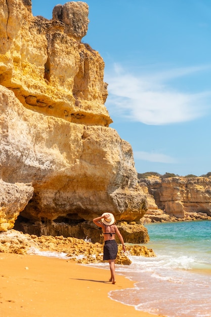 Kobieta w kapeluszu na wakacjach w Algarve na plaży w Praia da Coelha Albufeira Portugalia