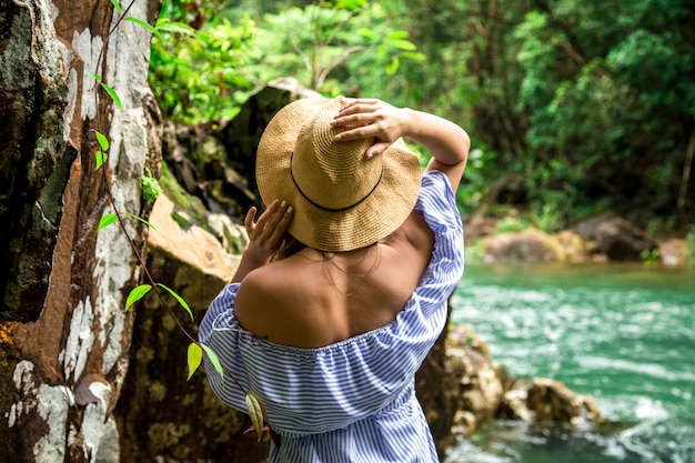 Kobieta w kapeluszu przy rzeką