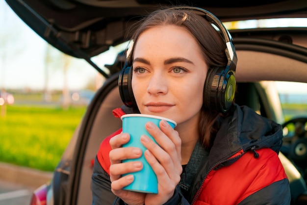 Kobieta w koncepcji jesieni samochodu Uśmiechnięta piękna dziewczyna słuchania muzyki