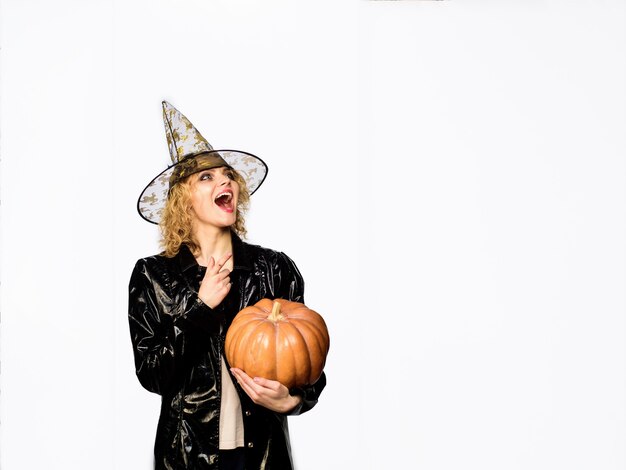 Kobieta w kostiumie na halloween z jasnym makijażem halloween czarownica z magiczną dynią happy halloween