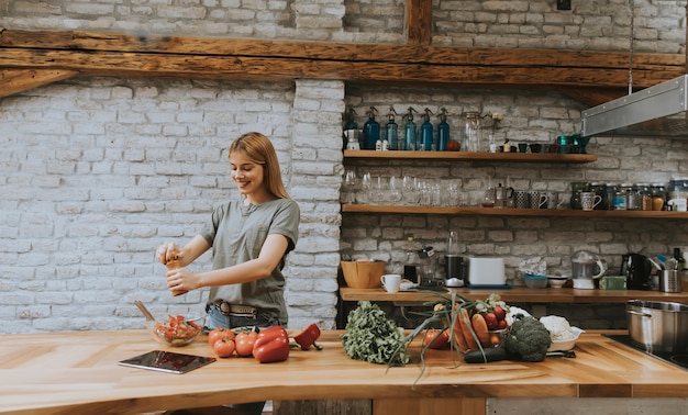 Zdjęcie kobieta w kuchni używa pastylka czytelniczego przepis