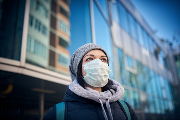 Kobieta w masce na ulicy, ponieważ epidemia koronawirusa w mieście.