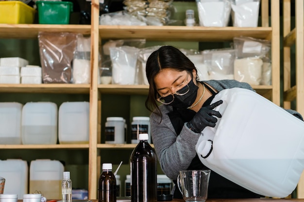 Kobieta w masce w magazynie przetwarzającym produkty chemiczne.