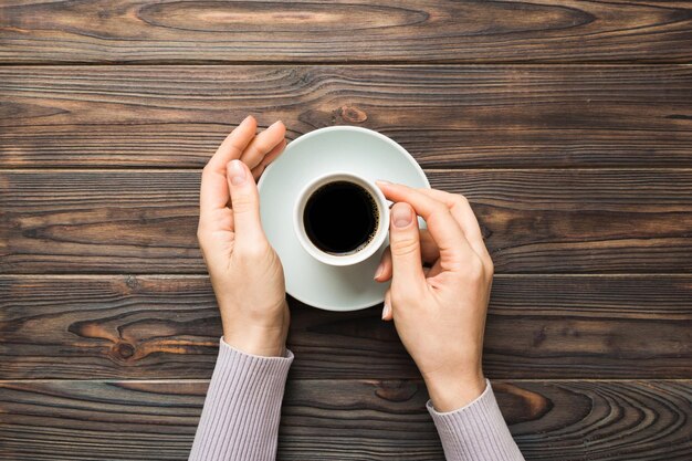 Kobieta w minimalistycznym stylu ręka trzyma filiżankę kawy na kolorowym tle Leżał płasko widok z góry Filiżanka espresso Puste miejsce na miejsce kopiowania tekstu Uzależnienie od kawy Widok z góry leżał płasko