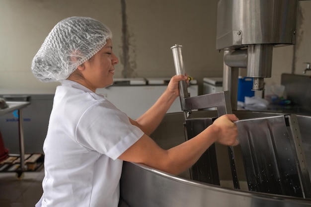 Kobieta w mundurze pracująca w fabryce przetwórstwa mleka