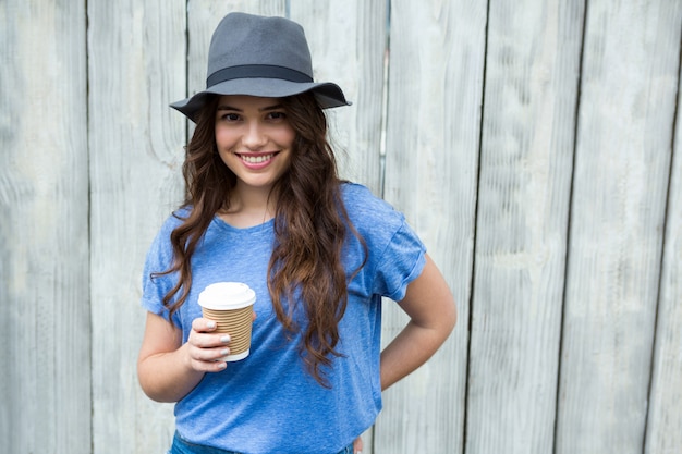 Kobieta w niebieskim top gospodarstwa filiżankę kawy jednorazowego użytku