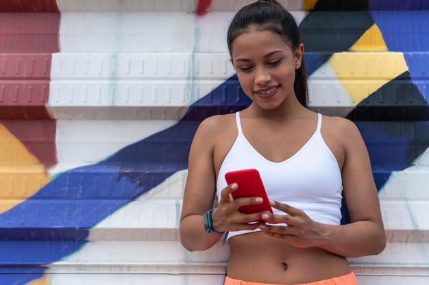 Kobieta w odzieży sportowej za pomocą inteligentnego telefonu. Koncepcja zdrowego życia.