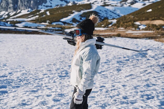 Zdjęcie kobieta w okularach narciarskich stojąca na pokrytej śniegiem ziemi