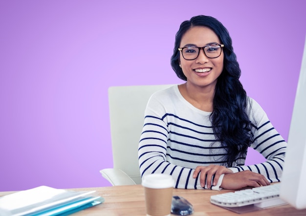 Kobieta w okularach siedząca na biurku na fioletowym tle