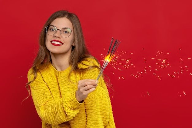 Kobieta W Okularach Trzymająca Zimne Ognie, Nosi Dzianinowy żółty Sweter