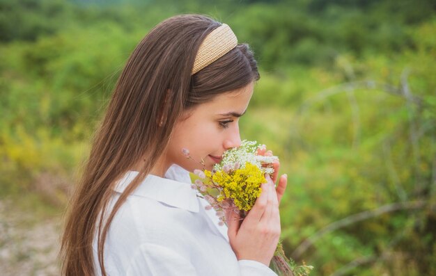 Kobieta w polu zdrowego stylu życia beztroska dziewczyna na łące z polnymi kwiatami