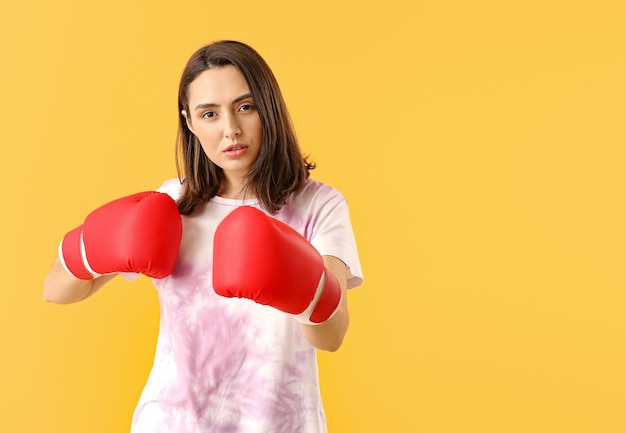 Kobieta w Rękawice bokserskie na kolorowym tle. Pojęcie feminizmu