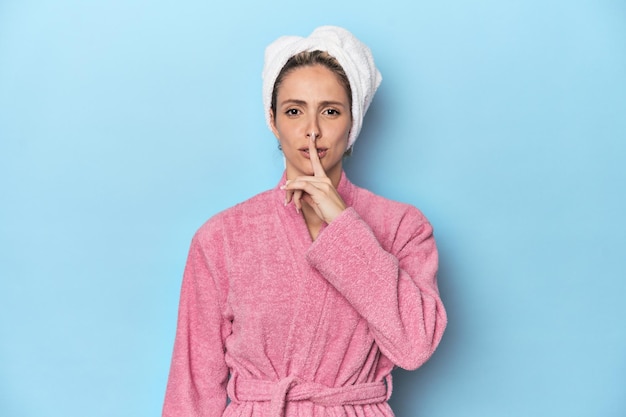 Kobieta w różowym szlafroku po prysznicu zachowuje tajemnicę lub prosi o ciszę