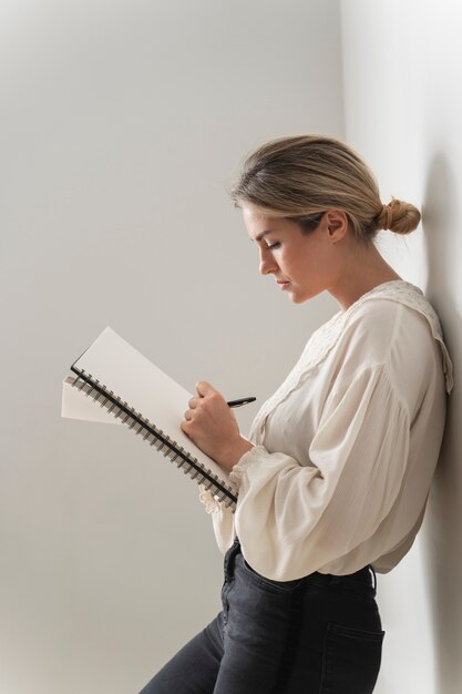 Zdjęcie kobieta w średnim ujęciu robi notatki