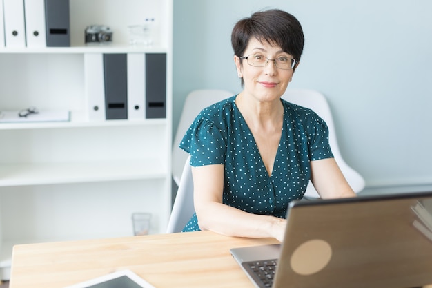 kobieta w średnim wieku pracuje w biurze i korzysta z laptopa