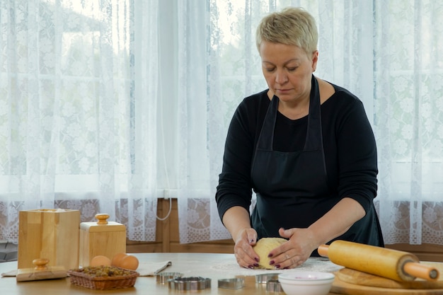 Kobieta W średnim Wieku W Czarnym Fartuchu Robi Domowe Ciasteczka Zacierania Ciasta