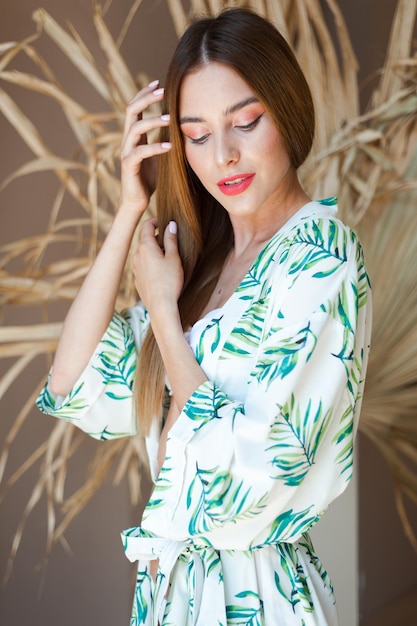 Kobieta w tropikalnej sukience z liśćmi palmowymi na włosach