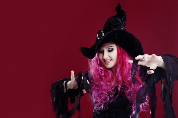 Zdjęcie kobieta w wiedźmy kapelusz i kostium z rudymi włosami. halloween