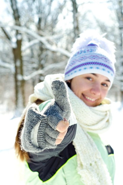 Kobieta w zimie daje kciuk w górę