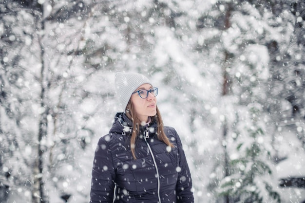 Kobieta w zimowej kurtce spaceru w śnieżnym zimowym lesie śnieżny zimowy dzień