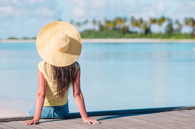 Kobieta w żółtym kapeluszu relaks w basenie w egzotycznym kurorcie