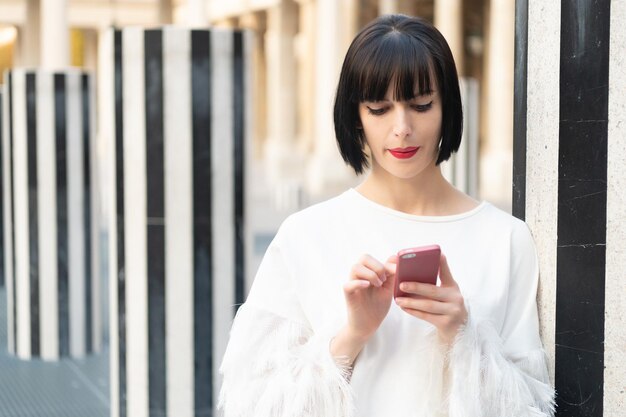 Kobieta wiadomości na telefon w przestrzeni kopiowania ulicy Kobieta wiadomości na telefon