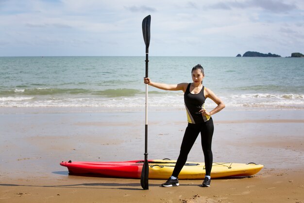 Kobieta wiosłowania kajakiem przez tropikalną plażę. Spływy kajakowe po Phuket w Tajlandii