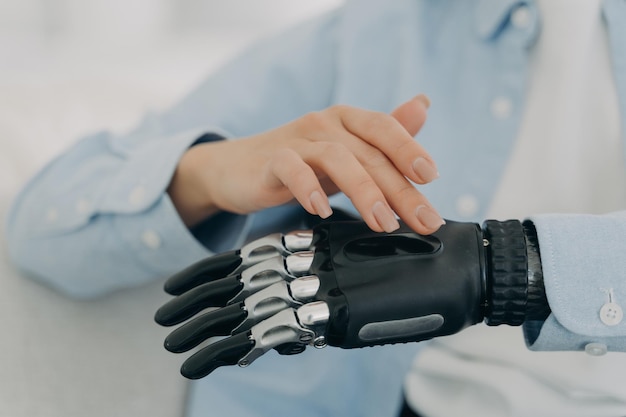 Kobieta włącza zaawansowaną technologicznie protezę ręki, sztuczną kończynę Reklama bionicznej protezy