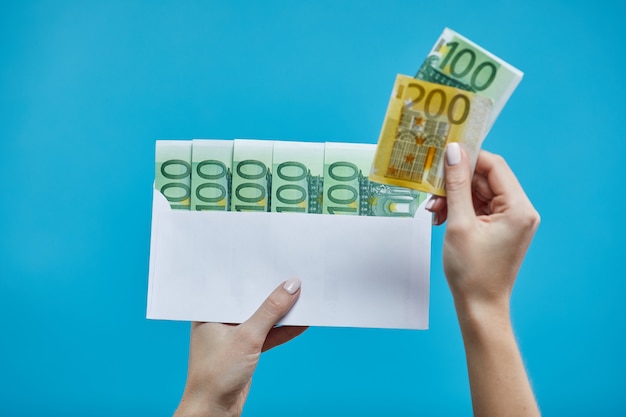 Kobieta wręcza mień euro banknoty w kopercie