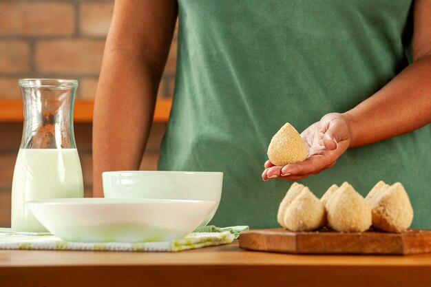 Kobieta Wręcza Panierowanie Brazylijskiego Krokieta Coxinha De Frango Z Bułką Tartą Na Drewnianym Stole W Kuchni